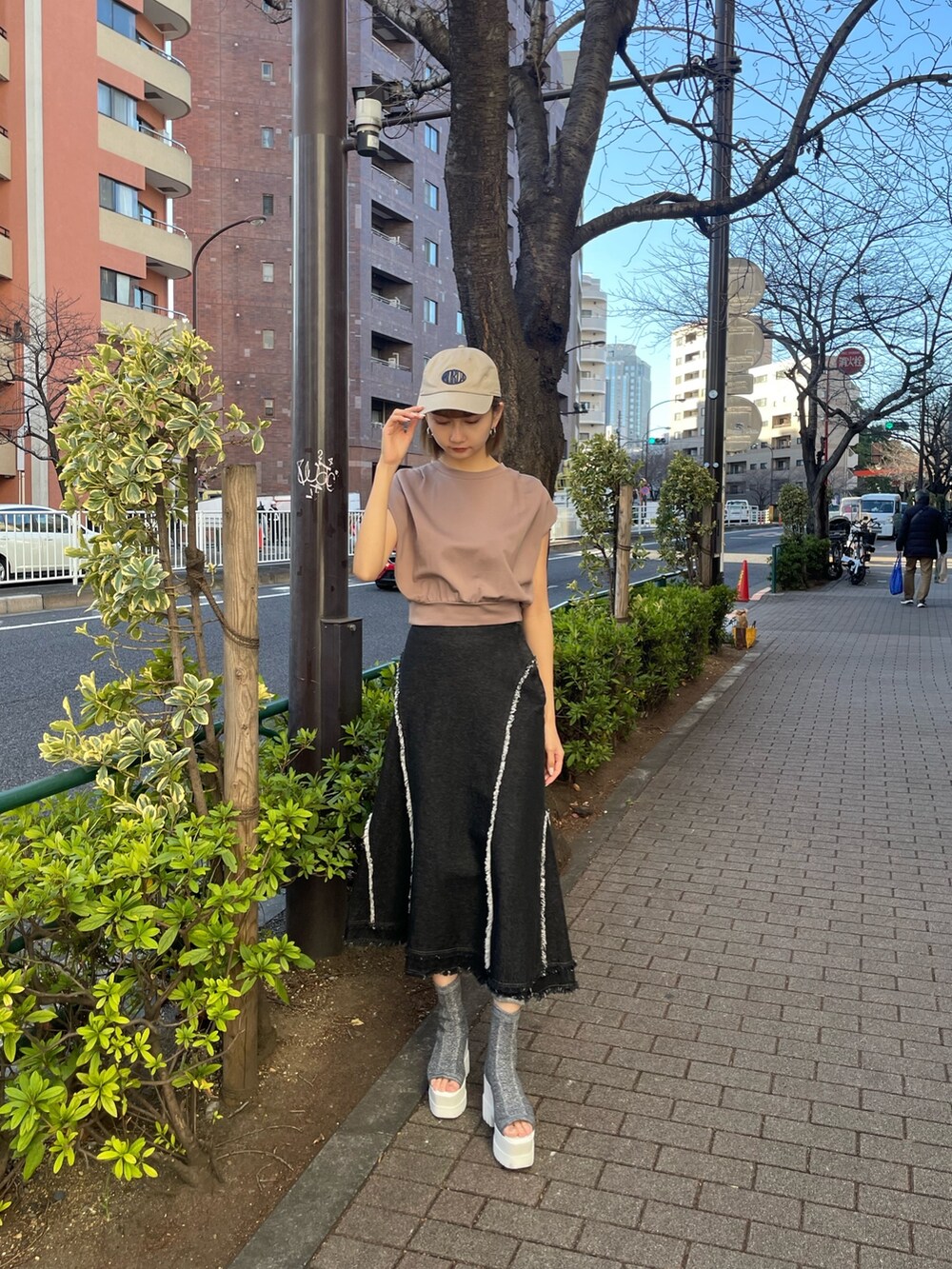 ブラウン系のTシャツ/カットソー、シルバー系のブーツ、ブラック系のデニムスカートを着用したレディースの冬コーディネートの2枚目の写真