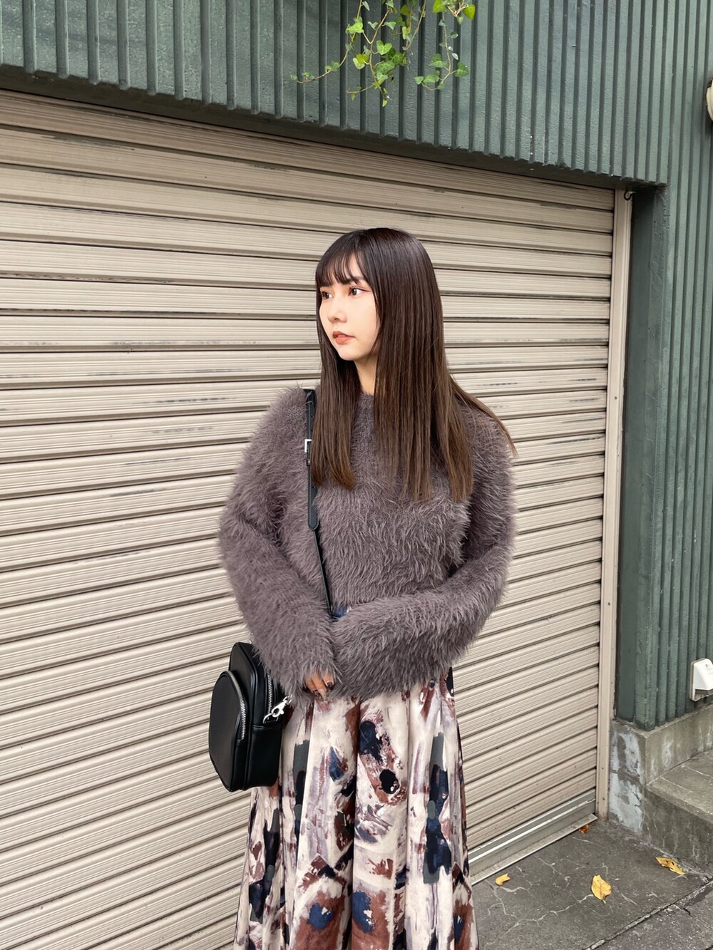 グレー系のニット/セーター、ブラック系のブーツ、ブルー系のスカートを着用したレディースの秋コーディネートの3枚目の写真