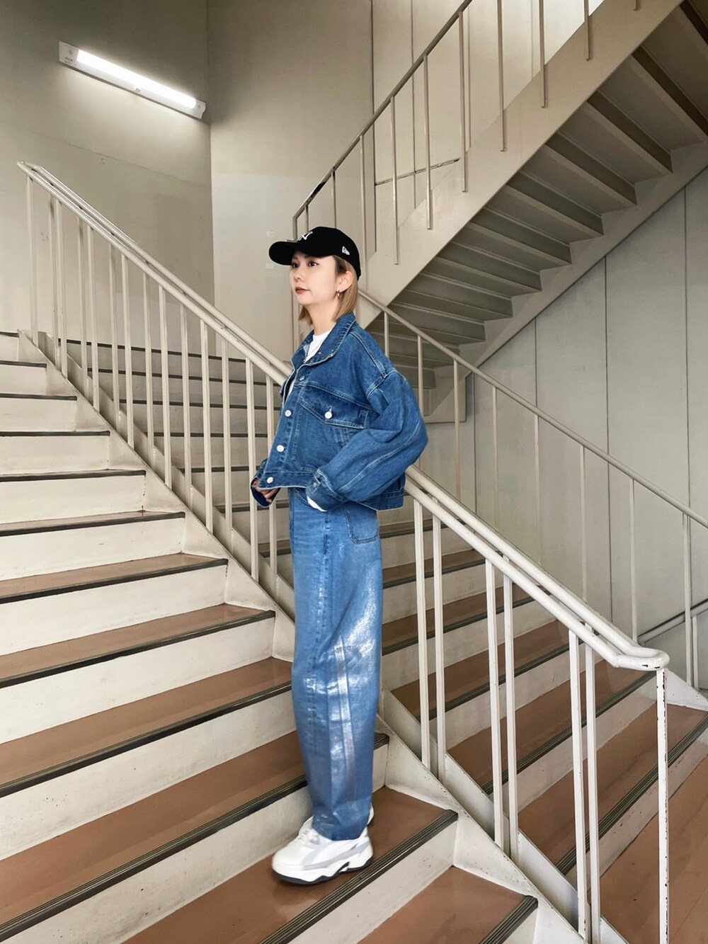 グレー系のスニーカー、ブルー系のデニムパンツ、ブルー系のデニムジャケットを着用したレディースの冬コーディネートの3枚目の写真