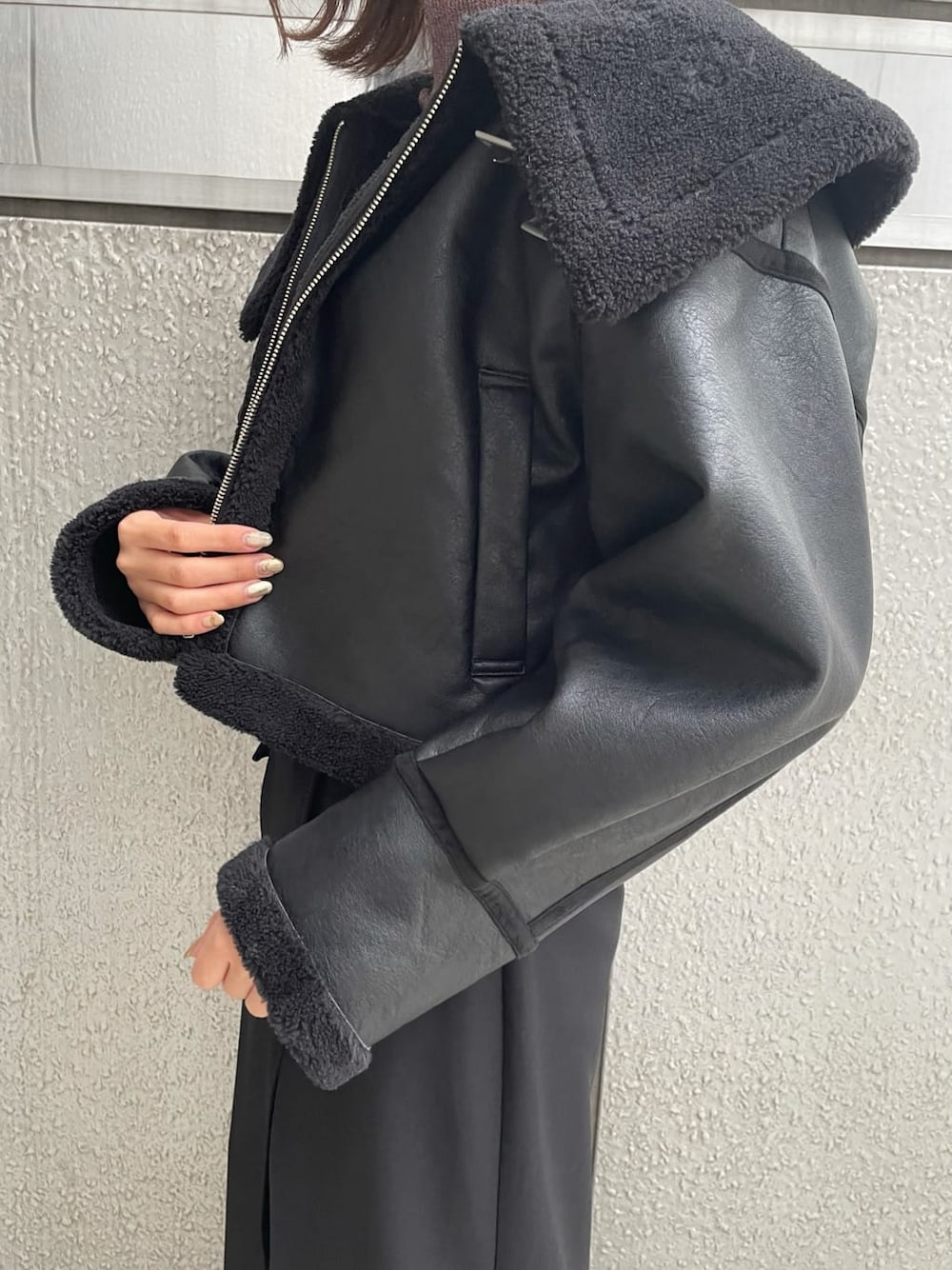 ブラック系のスカート、ブラック系のブルゾン、ホワイト系のブーツを着用したレディースの秋コーディネートの7枚目の写真