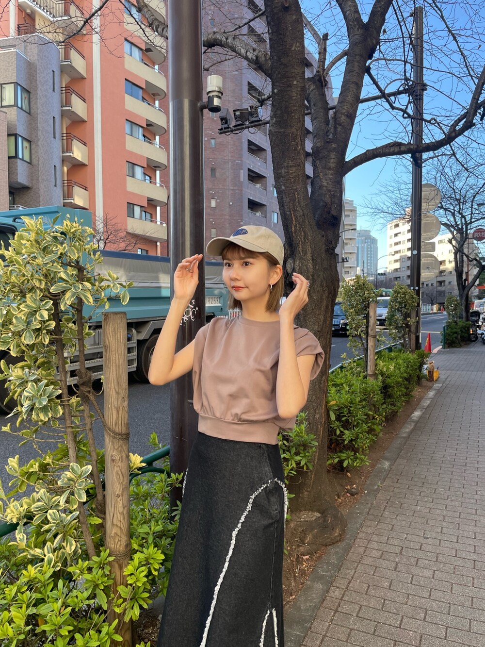 ブラウン系のTシャツ/カットソー、シルバー系のブーツ、ブラック系のデニムスカートを着用したレディースの冬コーディネートの3枚目の写真
