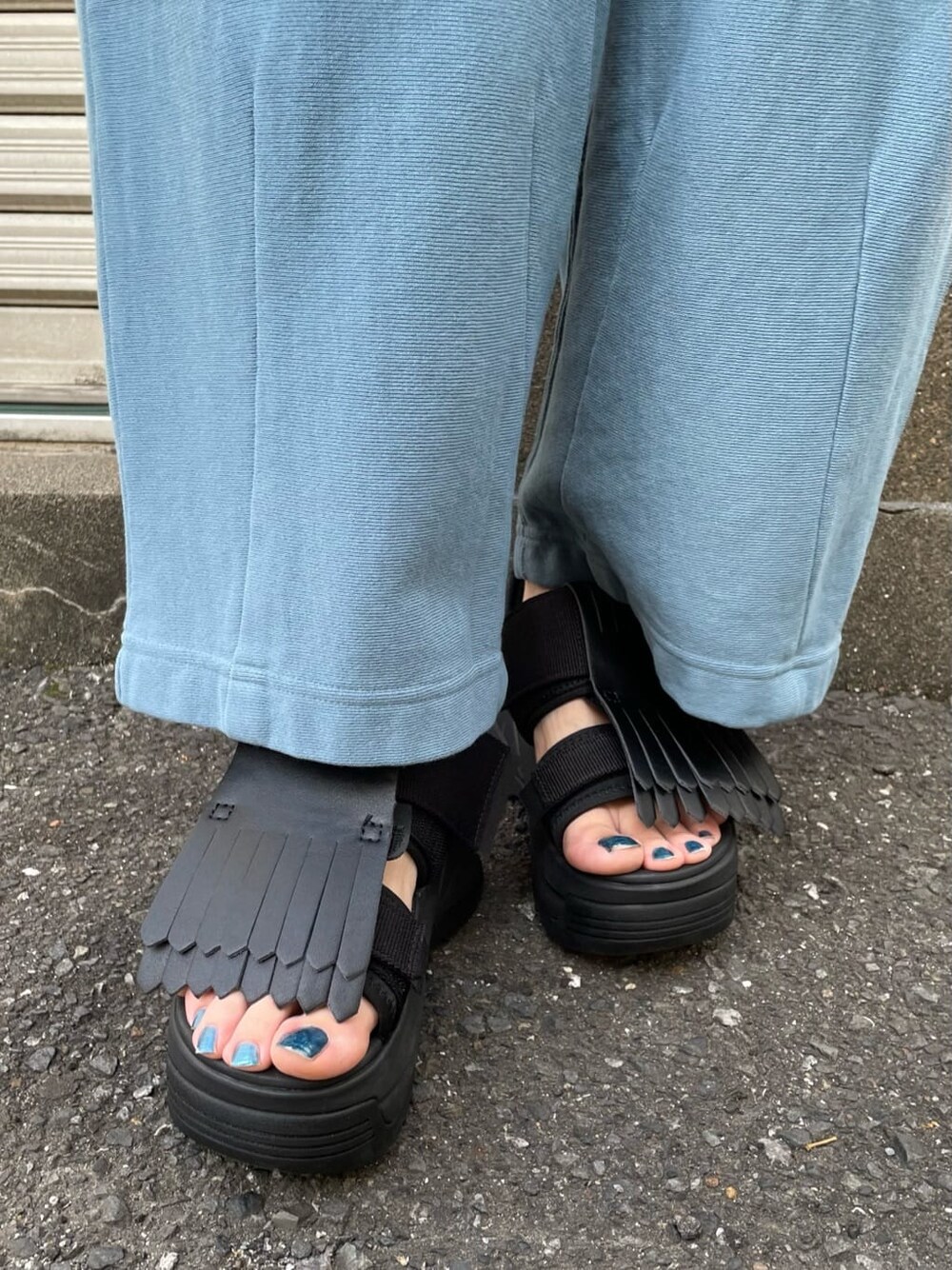 ブルー系のスウェットパンツ、ホワイト系のサンダル、ブラック系のTシャツ/カットソーを着用したレディースの春コーディネートの7枚目の写真