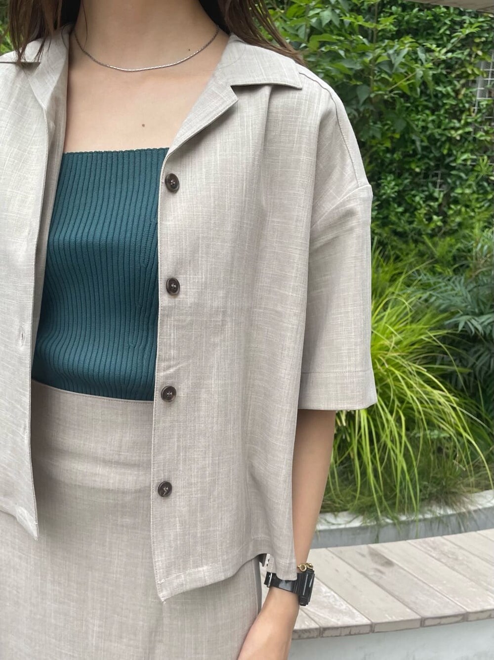 グリーン系のタンクトップ、ブラック系のサンダル、ブラック系のショルダーバッグを着用したレディースの夏コーディネートの5枚目の写真