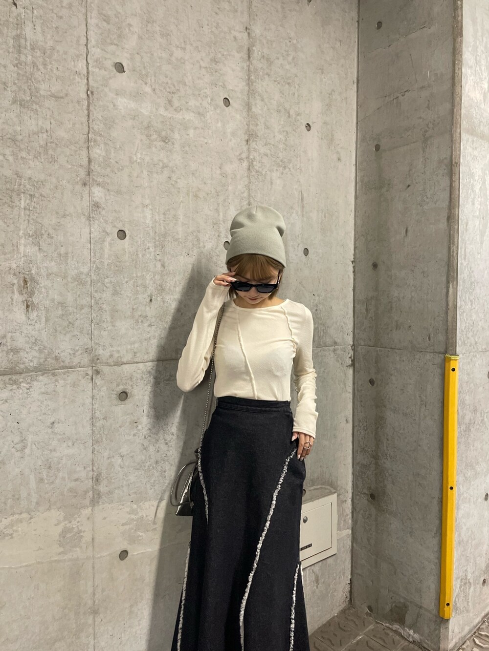 ホワイト系のTシャツ/カットソー、ホワイト系のTシャツ/カットソー、ブラック系のデニムスカートを着用したレディースの冬コーディネートの3枚目の写真
