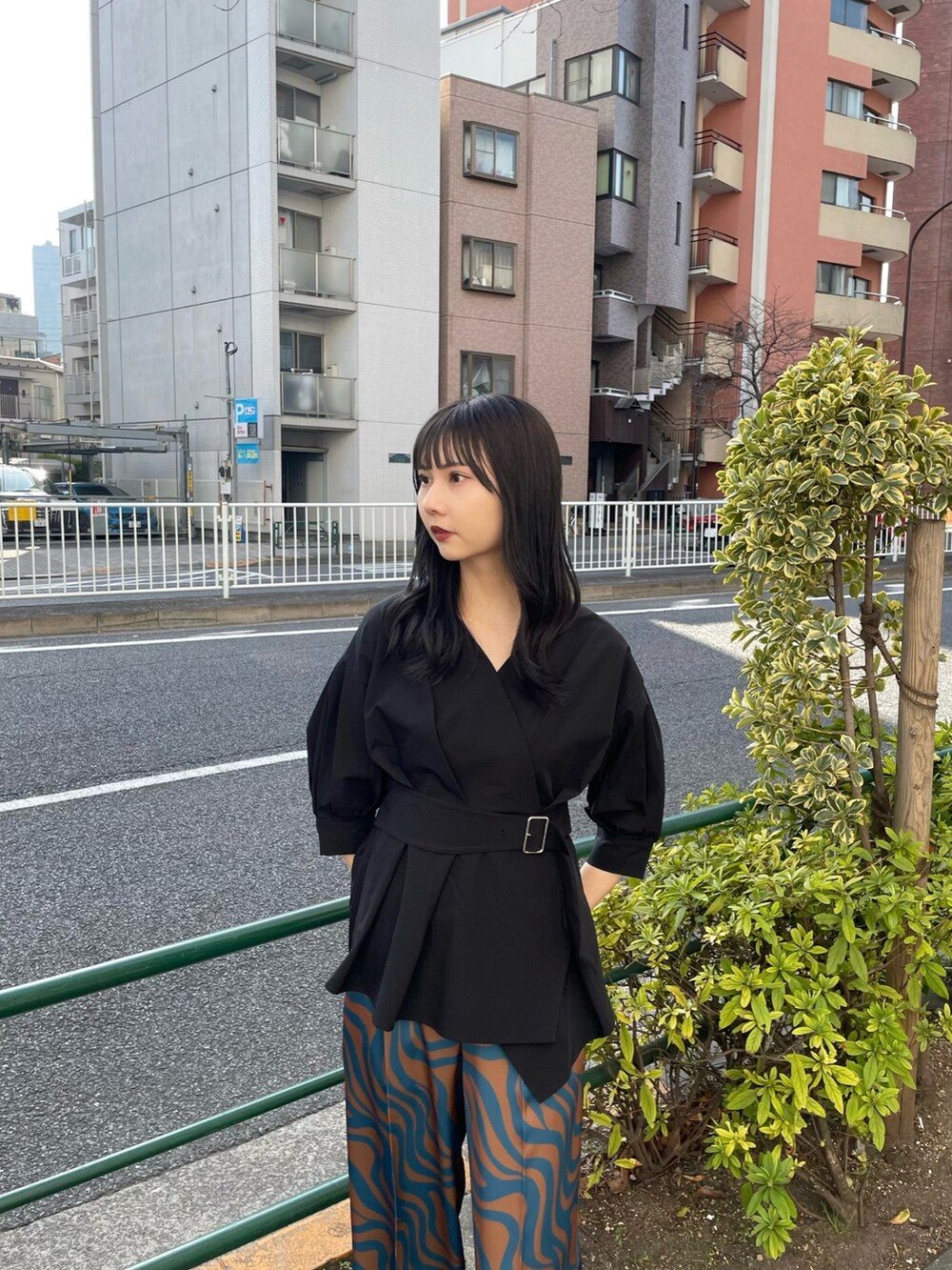 ブラック系のシャツ/ブラウス、ブルー系のスラックス、ブラック系のサンダルを着用したレディースの春コーディネートの2枚目の写真