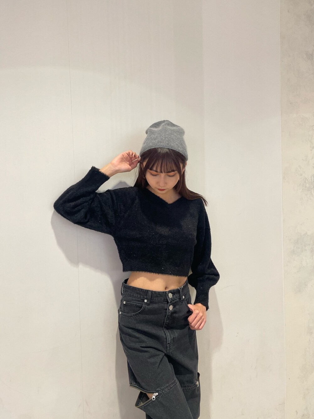 ブラック系のニット/セーター、ブラック系のデニムパンツ、ブラック系のブーツを着用したレディースの秋コーディネートの3枚目の写真