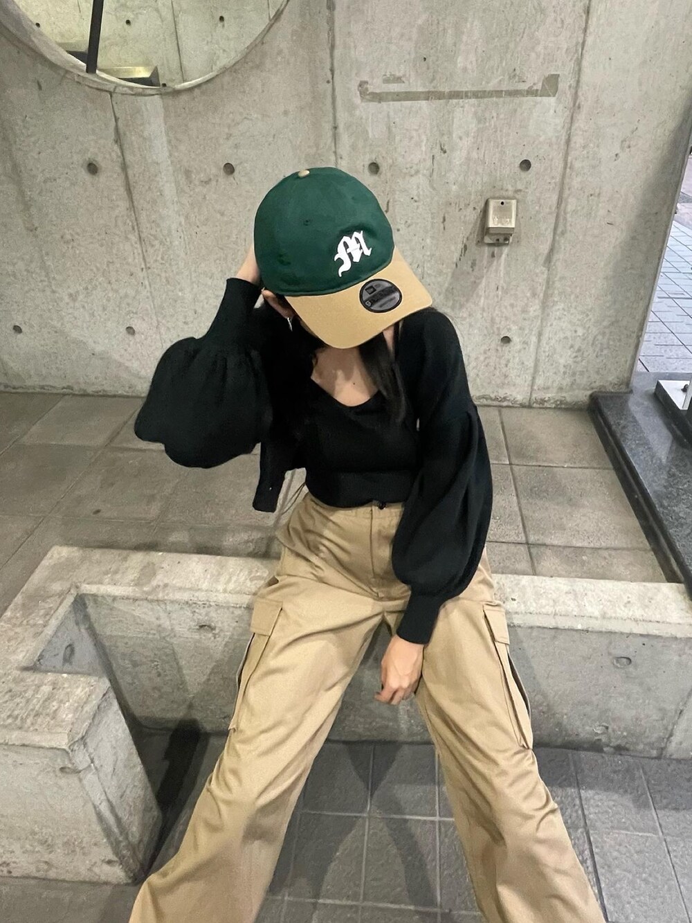 ブラック系のカーディガン/ボレロ、ベージュ系のカーゴパンツ、ブラック系のブーツを着用したレディースの秋コーディネートの3枚目の写真