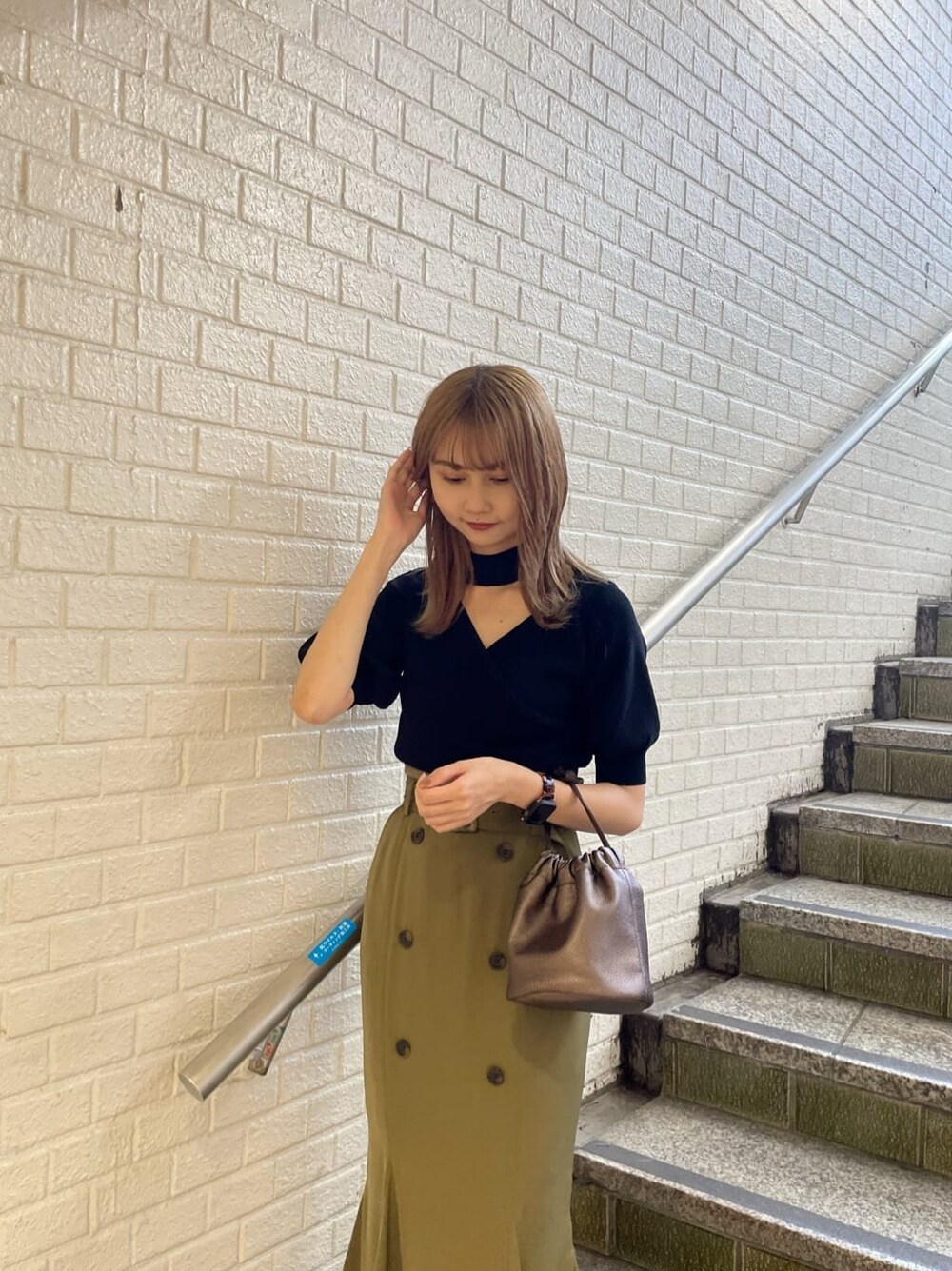 ベージュ系のスカート、ブラック系のニット/セーターを着用したレディースの夏コーディネートの3枚目の写真