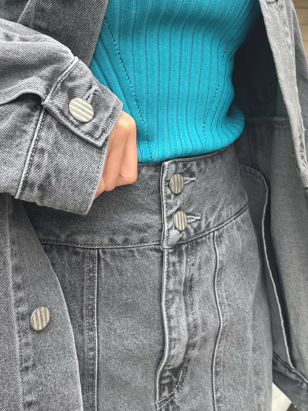 グレー系のデニムジャケット、グレー系のスカート、ブラック系のブーツを着用したレディースの冬コーディネートの9枚目の写真