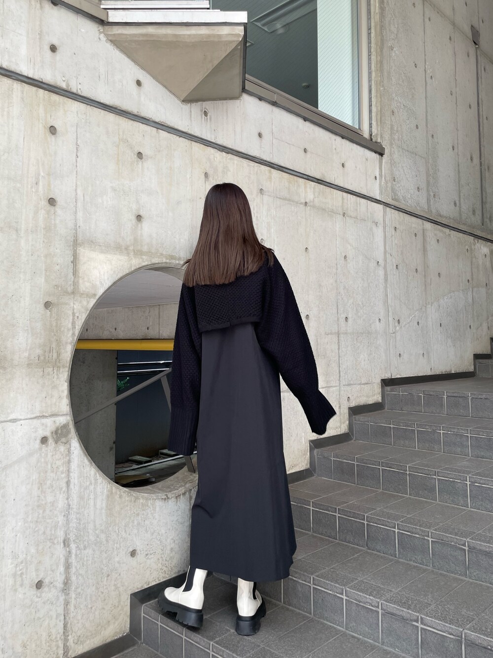 ブラック系のワンピース、ホワイト系のブーツを着用したレディースの秋コーディネートの3枚目の写真