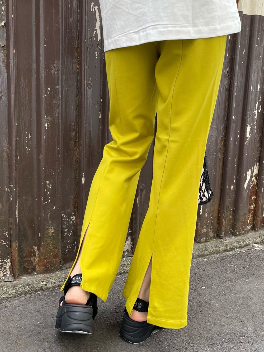 ブラック系のサンダル、ブラック系のハンドバッグ、ホワイト系のTシャツ/カットソーを着用したレディースの春コーディネートの7枚目の写真