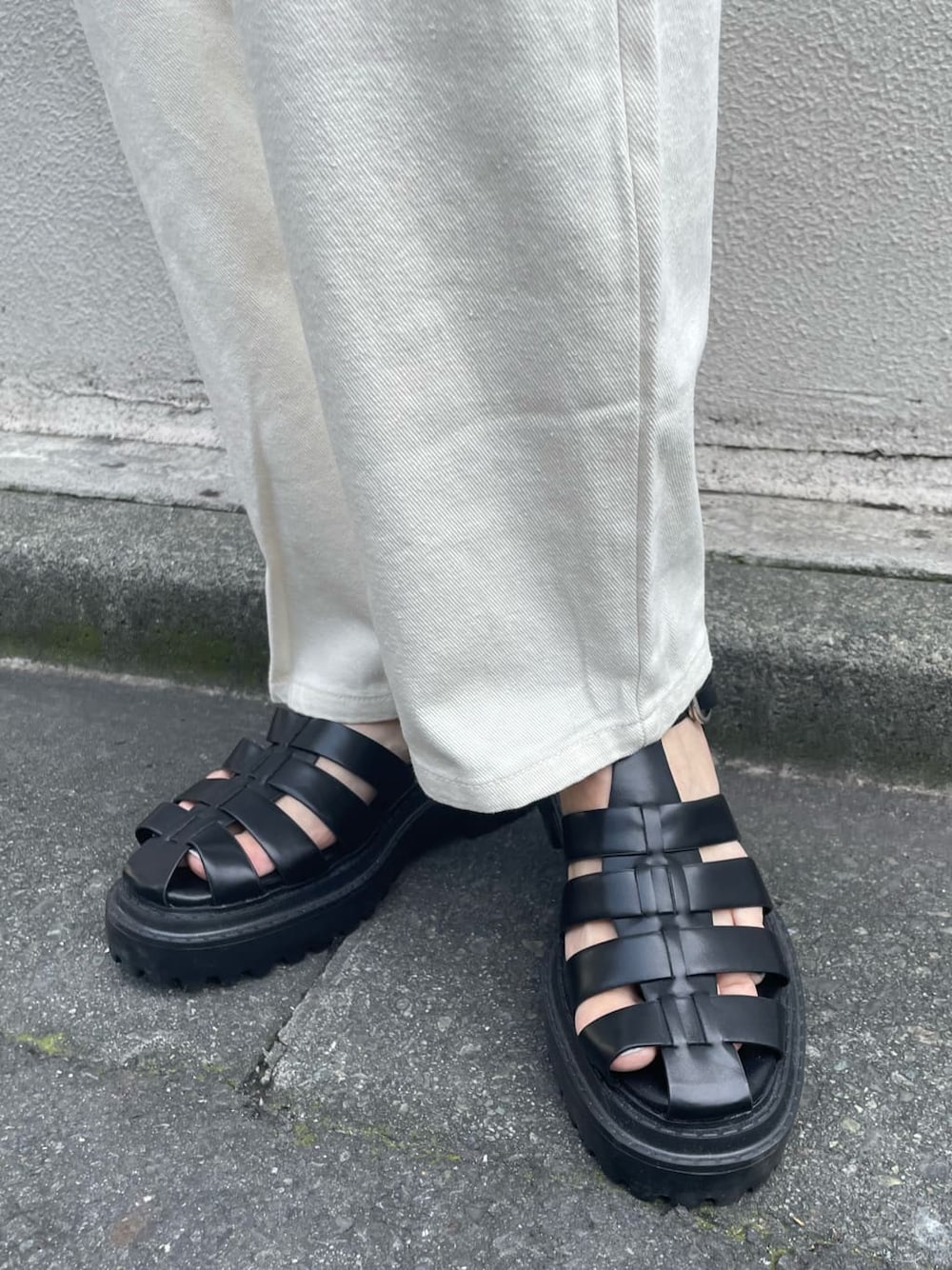 オレンジ系のポロシャツ、ホワイト系のデニムパンツ、ブラック系のサンダルを着用したレディースの夏コーディネートの7枚目の写真