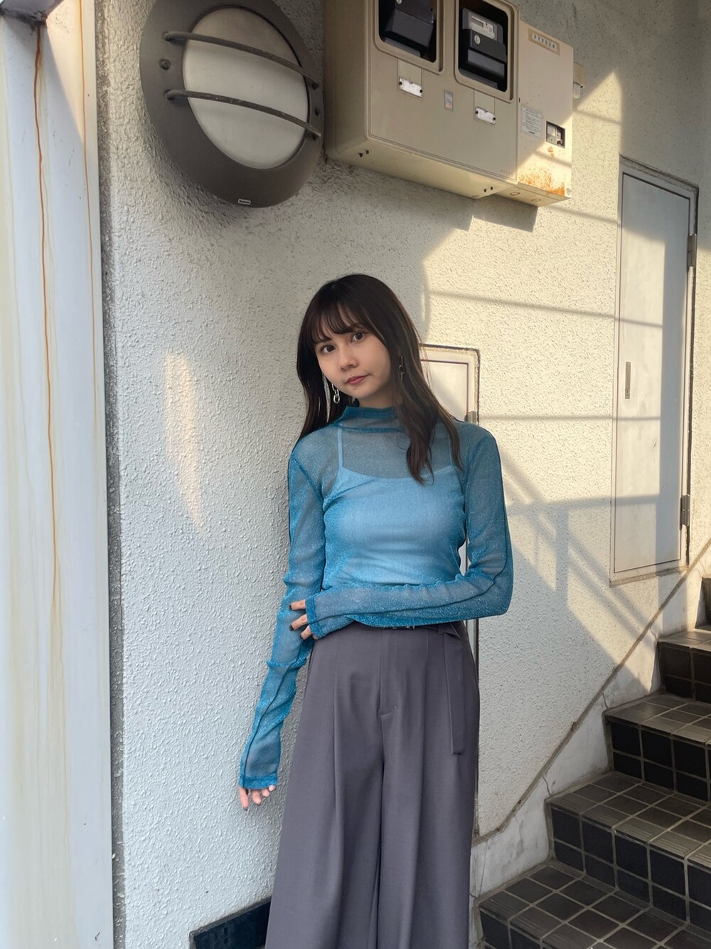 グレー系のスラックス、ブルー系のTシャツ/カットソー、ブラック系のブーツを着用したレディースの夏コーディネートの4枚目の写真