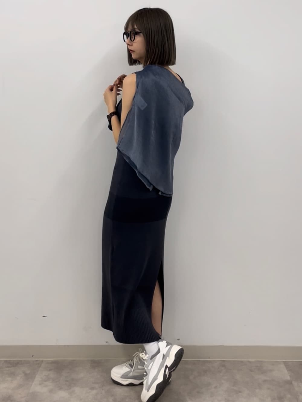 グレー系のワンピース、ブルー系のシャツ/ブラウス、グレー系のスニーカーを着用したレディースの春コーディネートの2枚目の写真