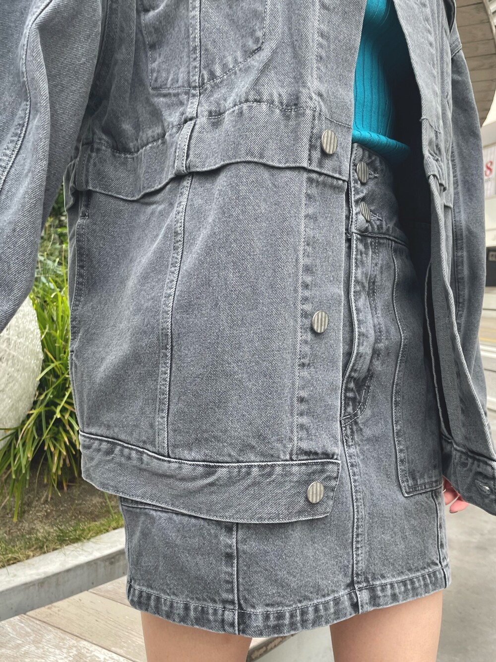 グレー系のデニムジャケット、グレー系のスカート、ブラック系のブーツを着用したレディースの冬コーディネートの8枚目の写真