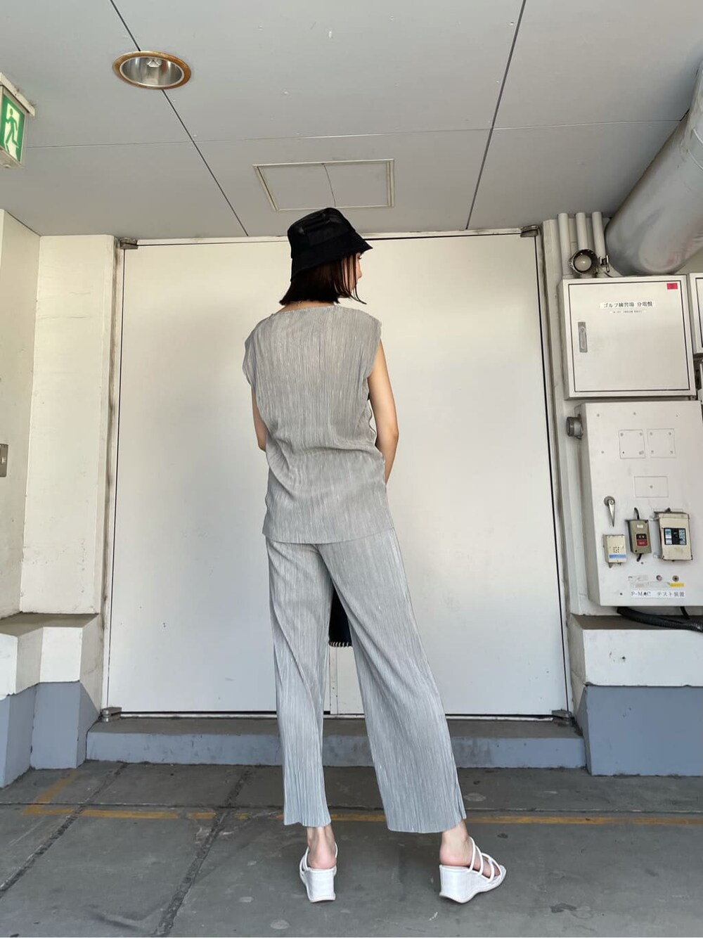 グレー系のスウェットパンツ、ブラック系のハンドバッグ、ホワイト系のサンダルを着用したレディースの夏コーディネートの4枚目の写真