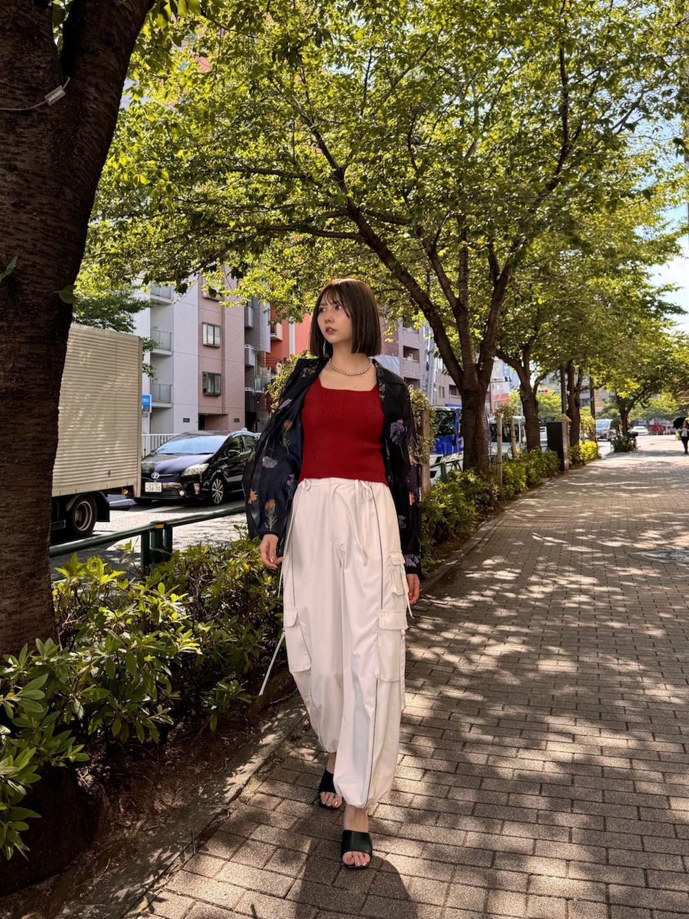 ブラック系のシャツ/ブラウス、レッド系のニット/セーター、ホワイト系のカーゴパンツを着用したレディースの夏コーディネートの3枚目の写真