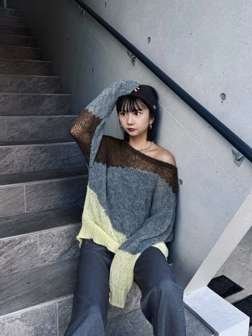 ブラウン系のブーツ、グレー系のニット/セーター、グレー系のニットキャップ/ビーニーを着用したレディースの秋コーディネートの2枚目の写真