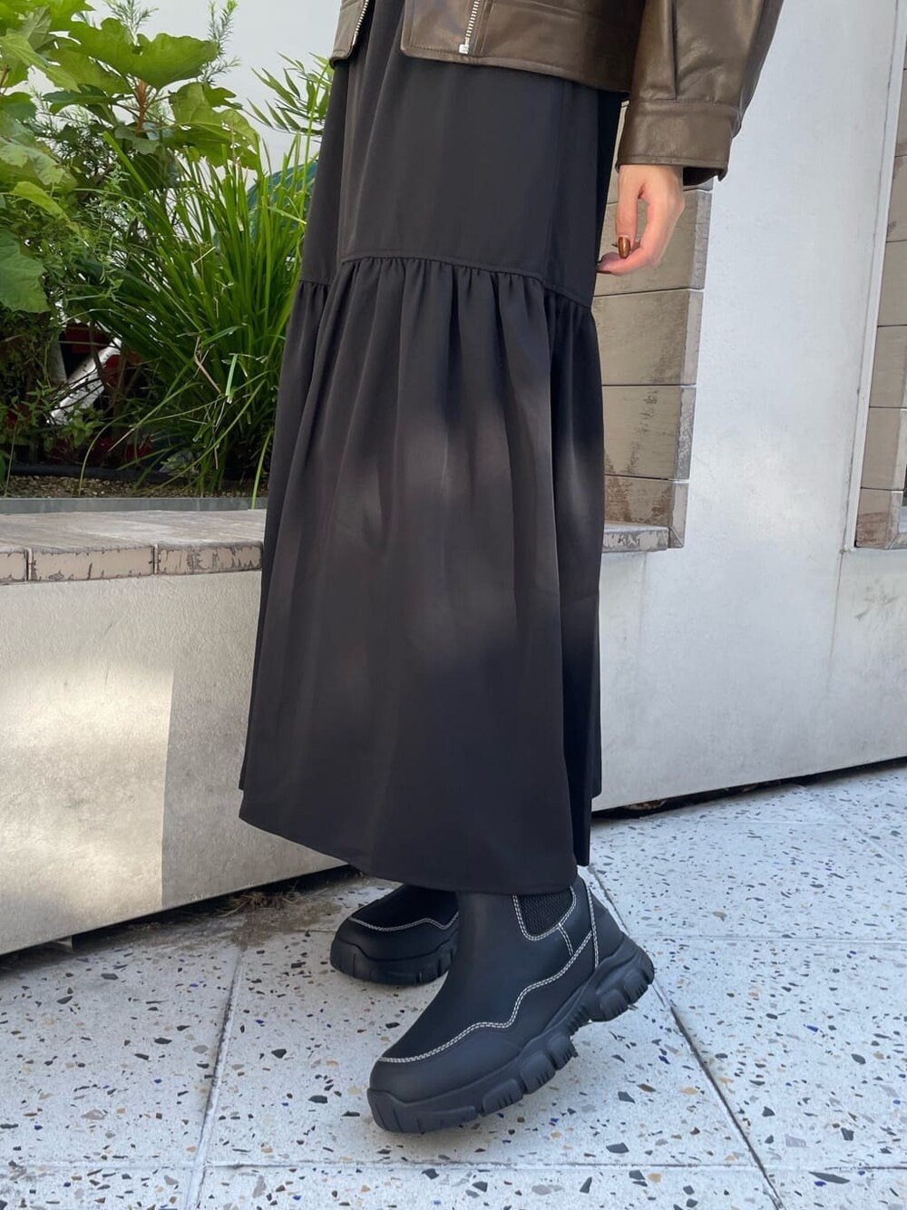 ブラック系のスカート、オレンジ系のニット/セーター、ブラック系のブーツを着用したレディースの秋コーディネートの6枚目の写真