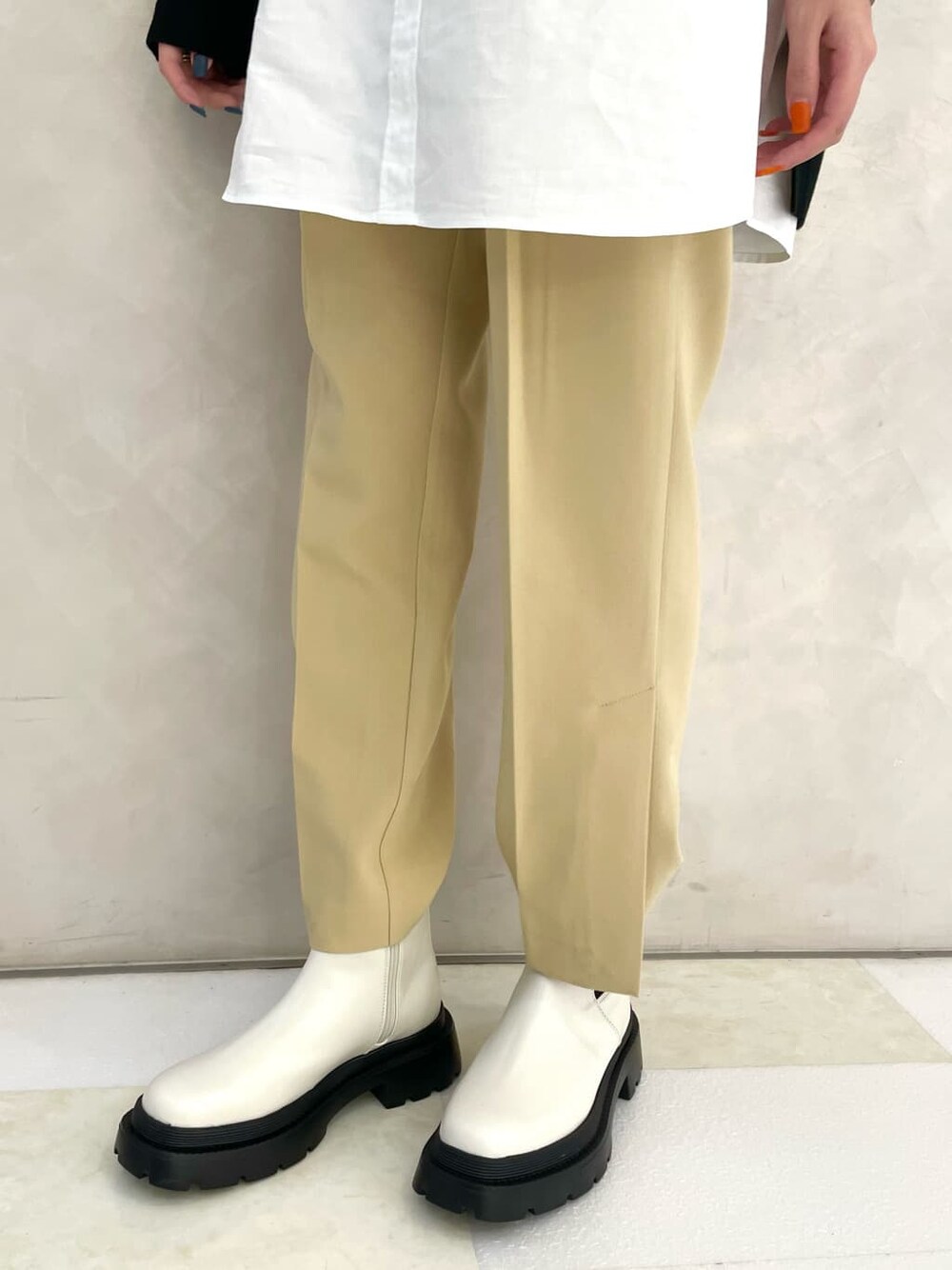 ホワイト系のブーツ、ブラック系のワンピース、イエロー系のスラックスを着用したレディースの冬コーディネートの4枚目の写真