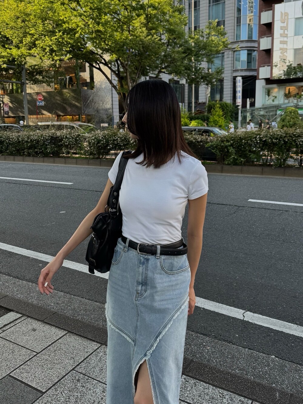 ブルー系のデニムスカート、シルバー系のパンプスを着用したレディースの夏コーディネートの2枚目の写真