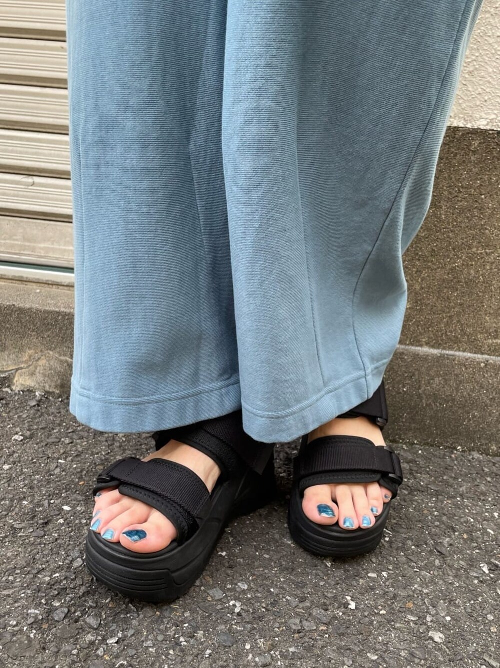 ブルー系のスウェットパンツ、ホワイト系のサンダル、ブラック系のTシャツ/カットソーを着用したレディースの春コーディネートの8枚目の写真