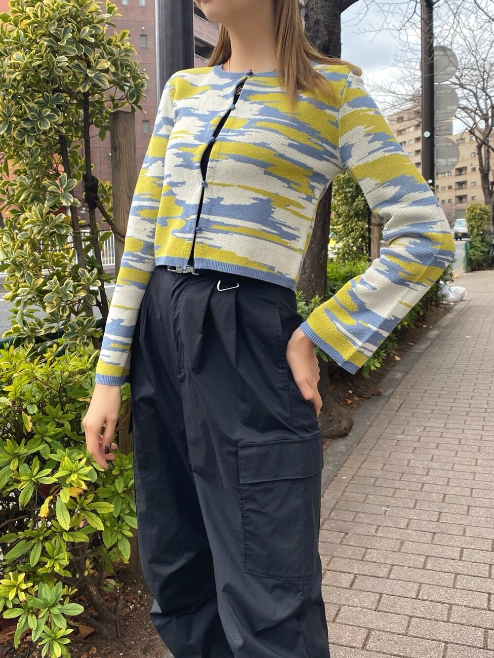 イエロー系のカーディガン/ボレロ、ホワイト系のハンドバッグ、ブラック系のカーゴパンツを着用したレディースの冬コーディネートの6枚目の写真