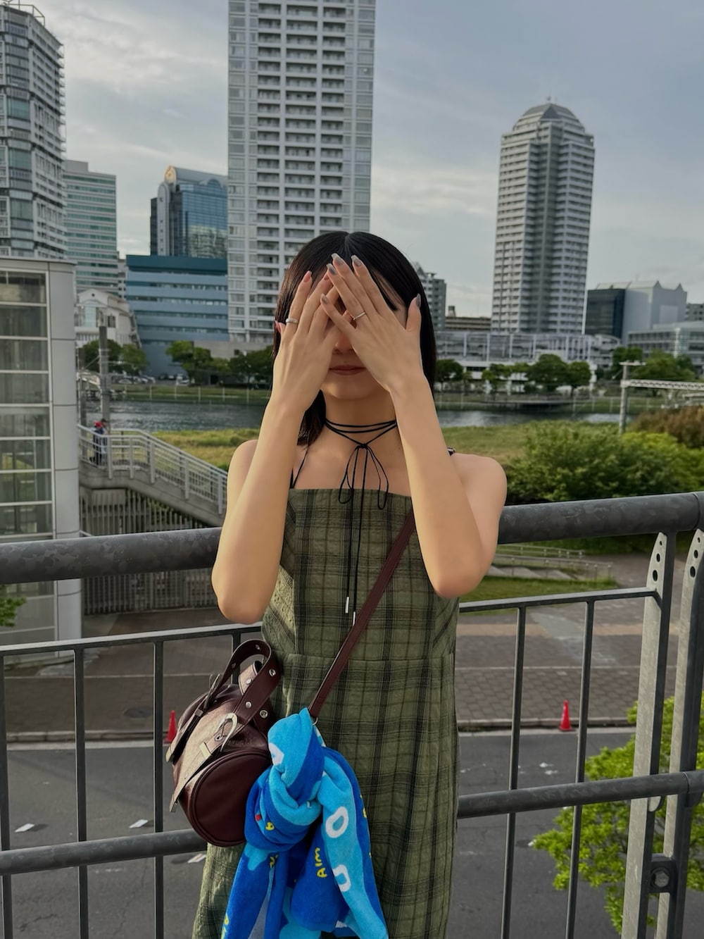 グリーン系のワンピース、レッド系のハンドバッグを着用したレディースの春コーディネートの2枚目の写真