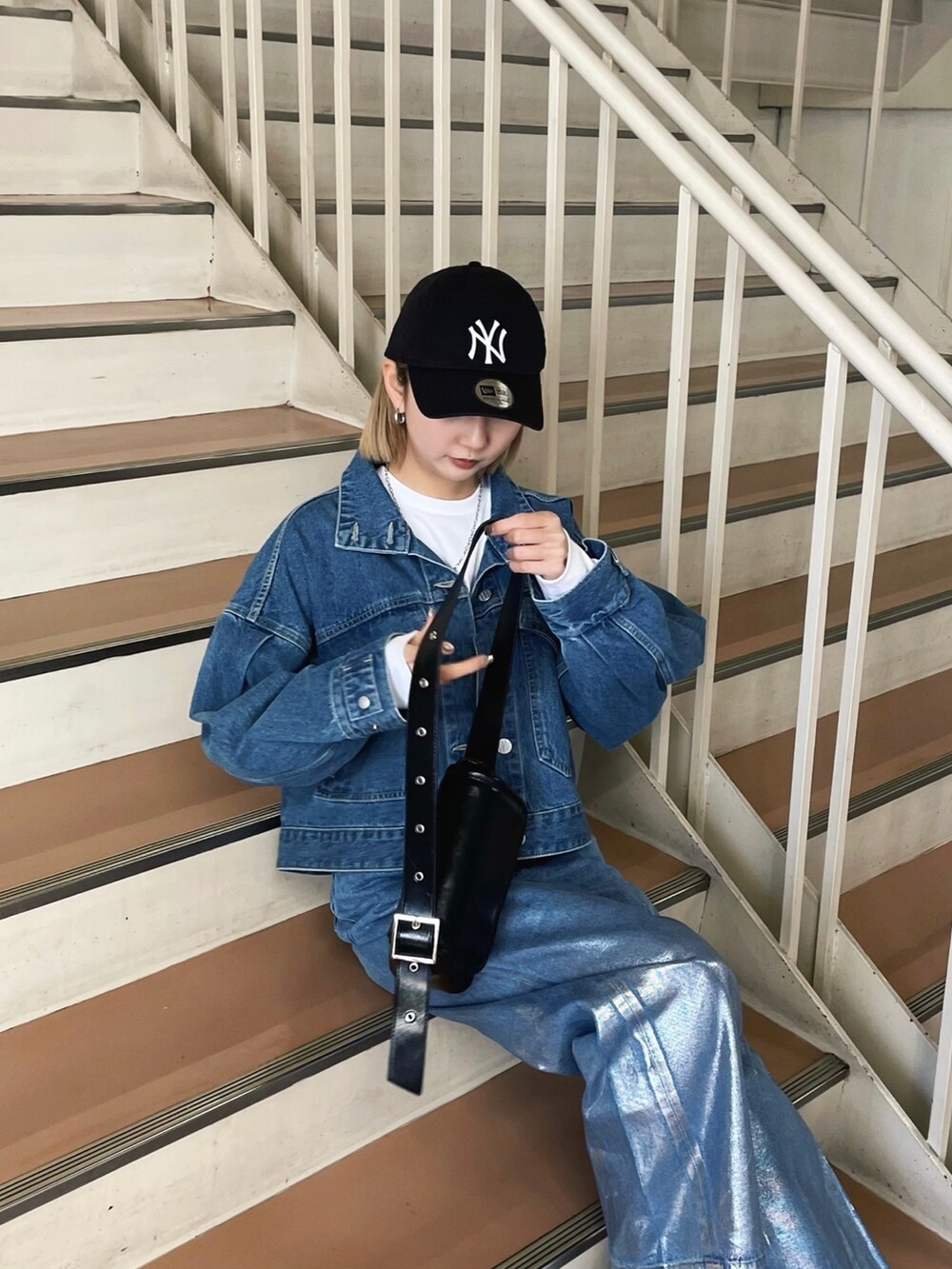 グレー系のスニーカー、ブルー系のデニムパンツ、ブルー系のデニムジャケットを着用したレディースの冬コーディネートの4枚目の写真