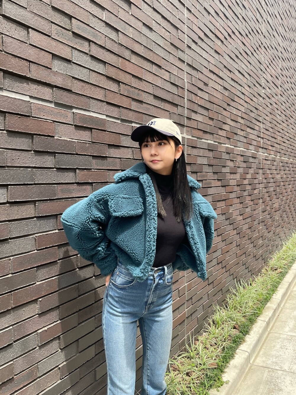 ブルー系のデニムパンツ、ブラック系のブーツ、ブルー系のブルゾンを着用したレディースの秋コーディネートの4枚目の写真