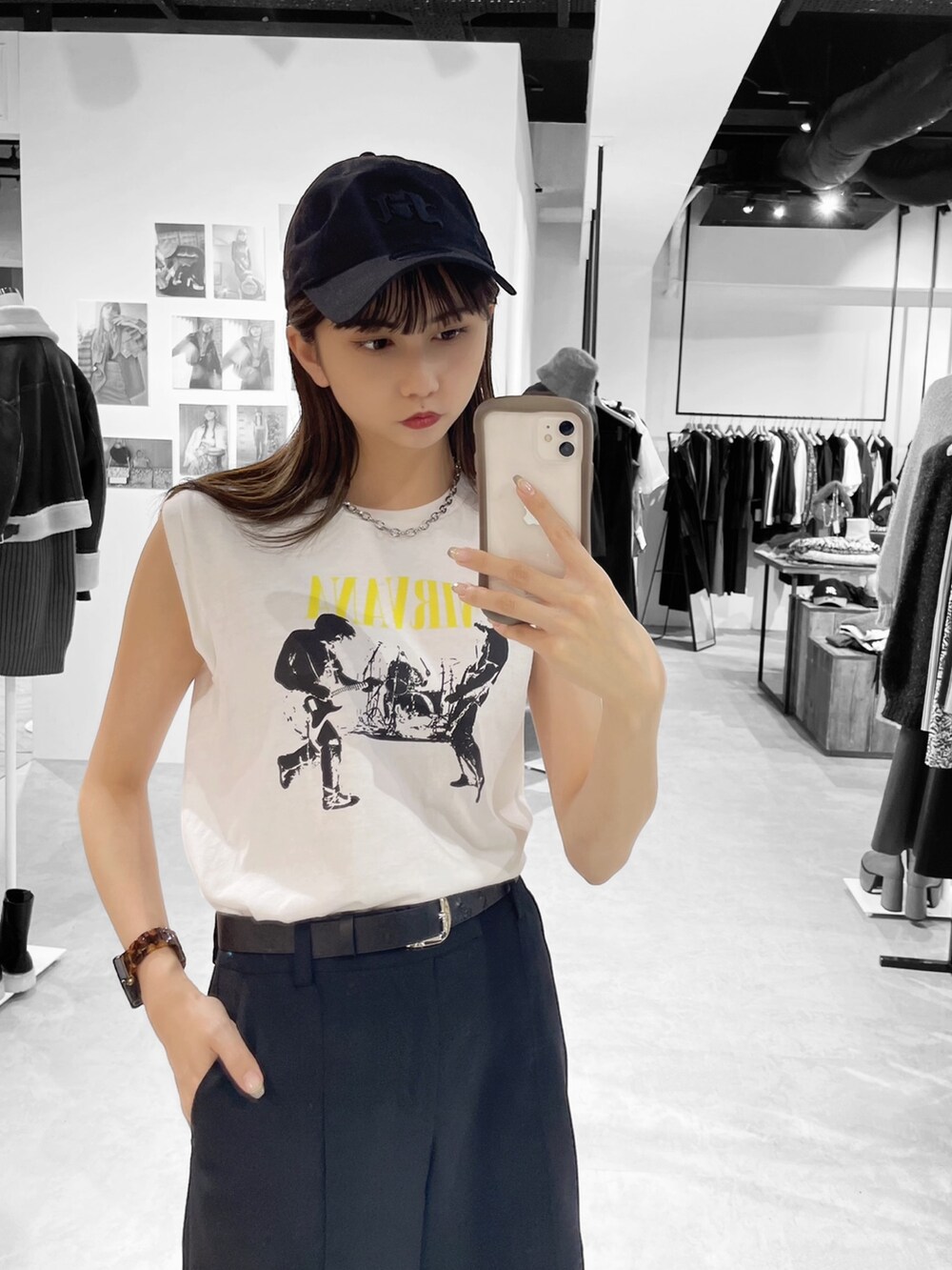 ホワイト系のタンクトップ、ブラック系のスラックスを着用したレディースの春コーディネートの2枚目の写真