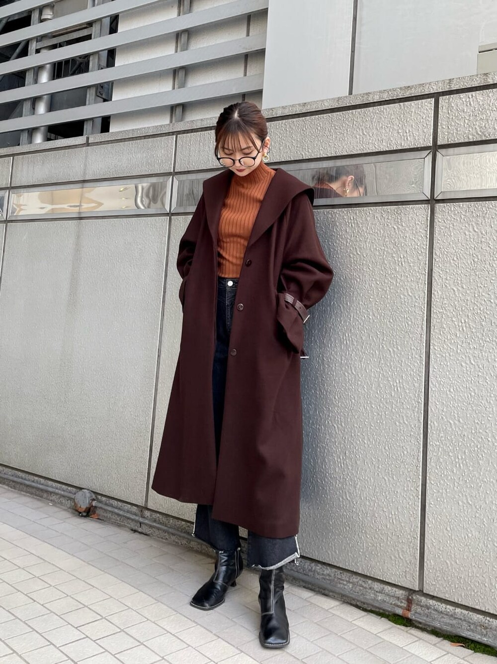 ブラック系のブーツ、ブラウン系のチェスターコート、ブラック系のデニムパンツを着用したレディースの冬コーディネートの2枚目の写真