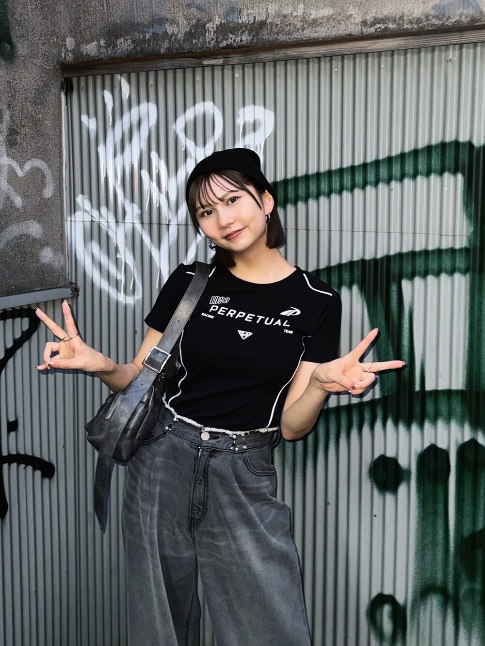 ブラック系のTシャツ/カットソー、ブラック系のデニムパンツを着用したレディースの夏コーディネートの3枚目の写真