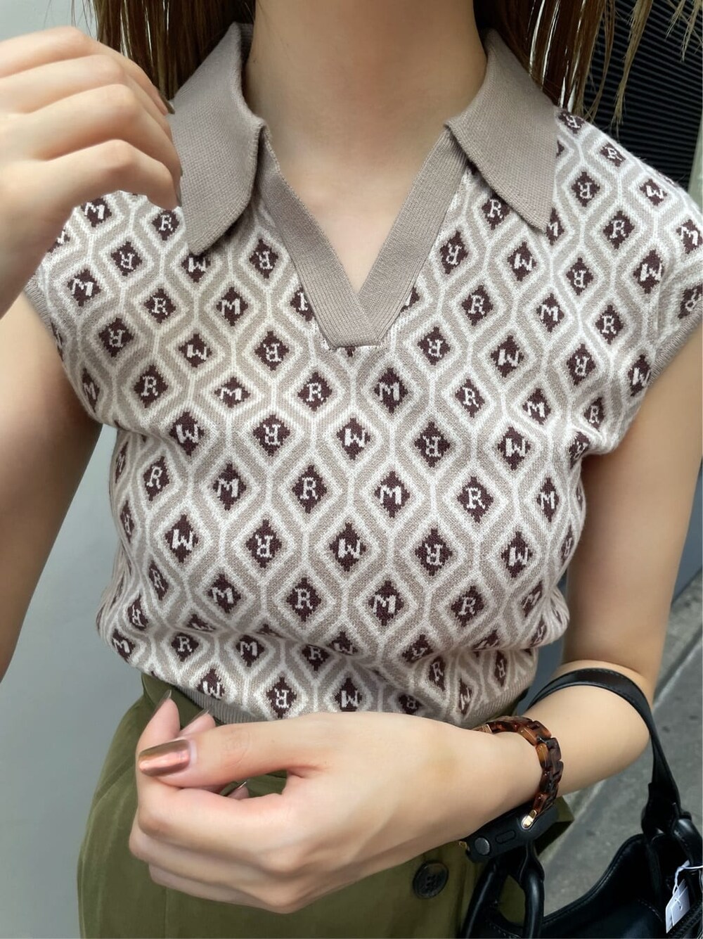 ベージュ系のスカート、ブラック系のハンドバッグ、ベージュ系のニット/セーターを着用したレディースの夏コーディネートの4枚目の写真