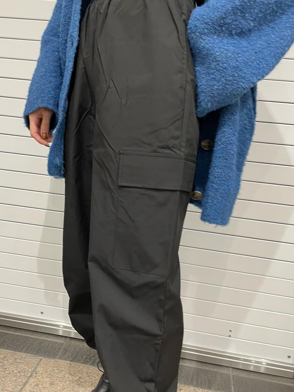 ブラック系のブーツ、ブルー系のカーディガン/ボレロ、ブラック系のカーゴパンツを着用したレディースの秋コーディネートの6枚目の写真