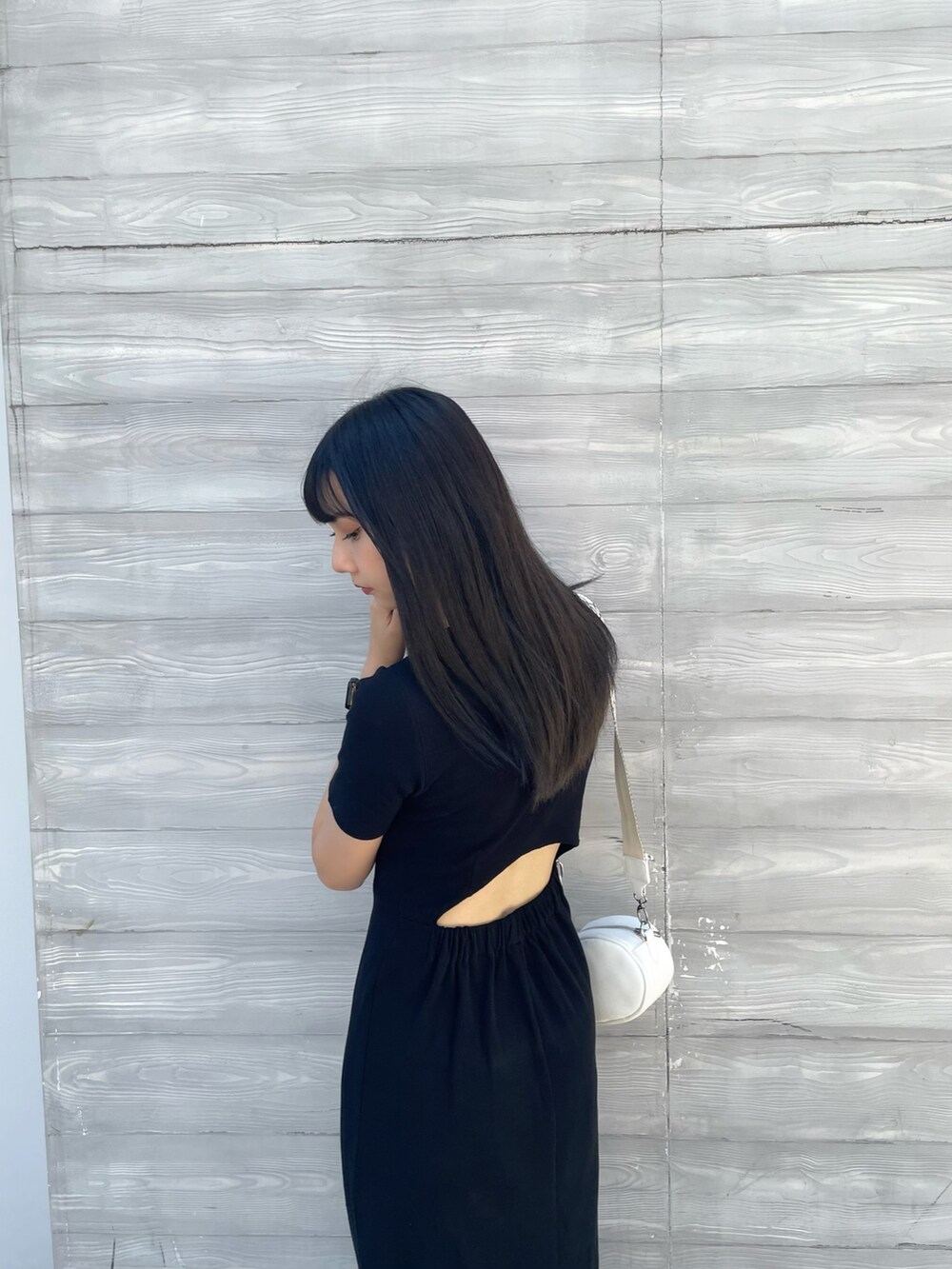 ホワイト系のショルダーバッグ、ブラック系のワンピースを着用したレディースの夏コーディネートの6枚目の写真