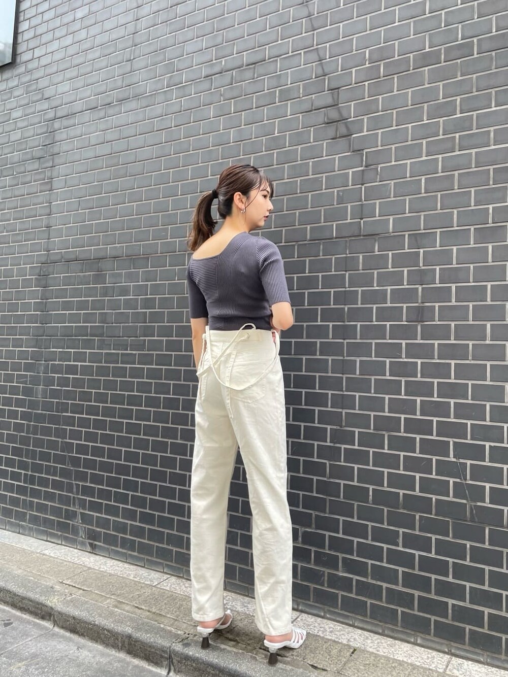 ホワイト系のデニムパンツ、ホワイト系のサンダル、グレー系のニット/セーターを着用したレディースの夏コーディネートの2枚目の写真