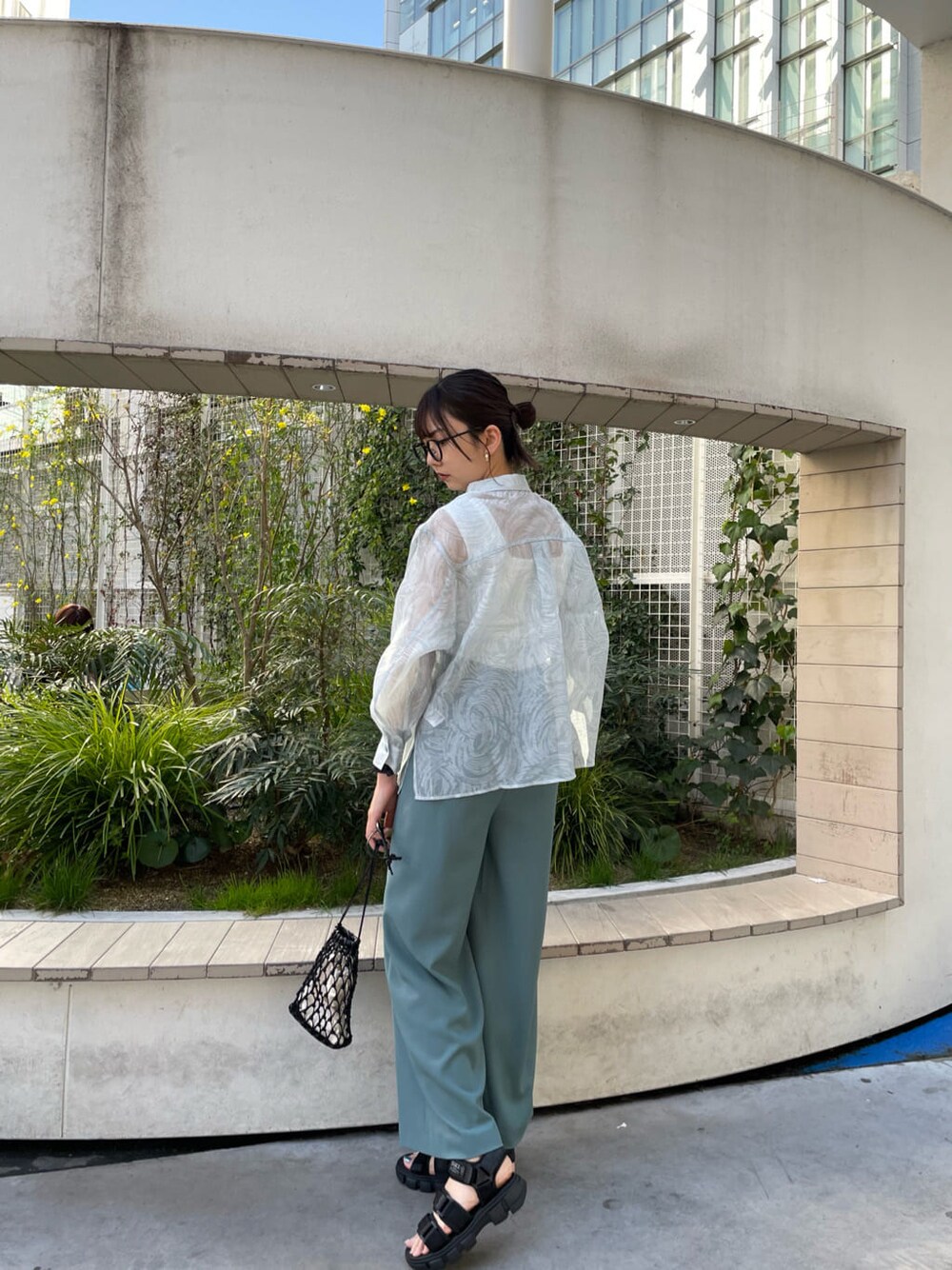 ホワイト系のタンクトップ、ブラック系のハンドバッグ、ブルー系のシャツ/ブラウスを着用したレディースの春コーディネートの2枚目の写真