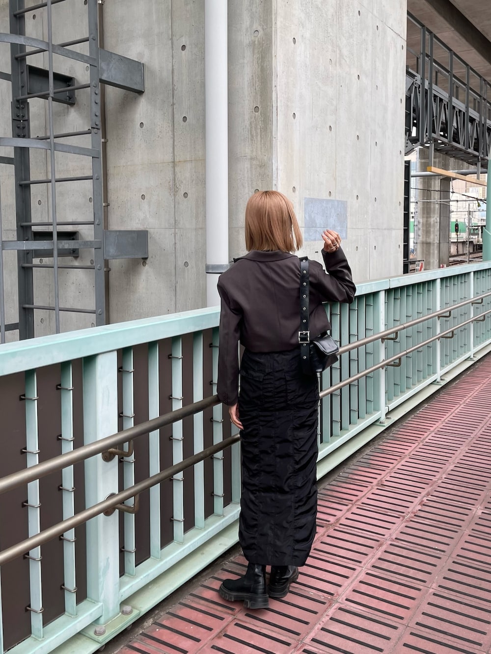 グレー系のテーラードジャケット、ブラック系のスカート、ブラック系のニット/セーターを着用したレディースの春コーディネートの3枚目の写真