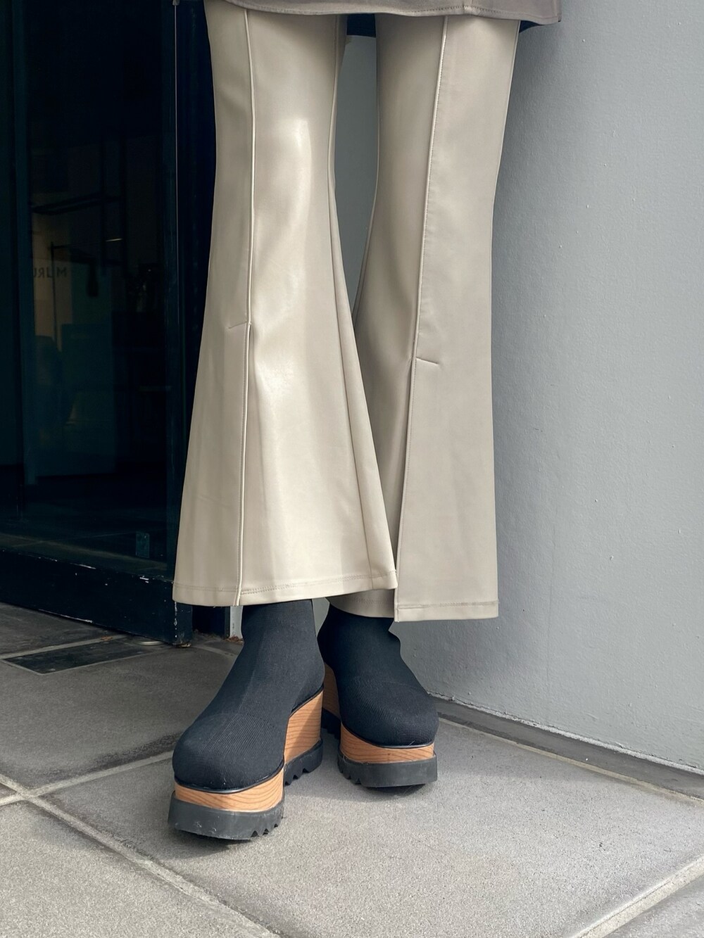 ホワイト系のワンピース、ホワイト系のスラックス、ブラック系のブーツを着用したレディースの冬コーディネートの6枚目の写真