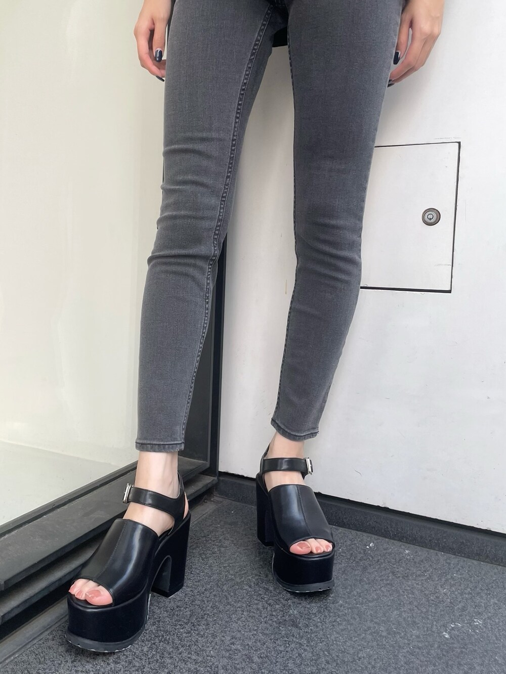 ブラック系のシャツ/ブラウス、グレー系のデニムパンツ、ブラック系のサンダルを着用したレディースの春コーディネートの5枚目の写真