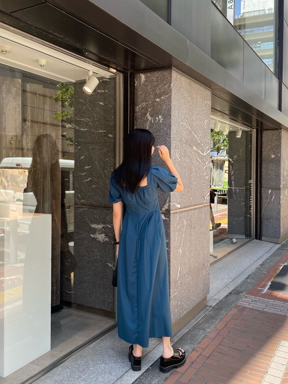 ブラック系のサンダル、ブルー系のワンピースを着用したレディースの夏コーディネートの4枚目の写真