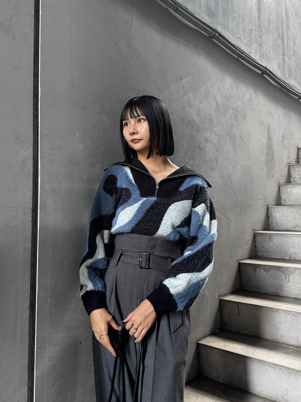 ブルー系のニット/セーター、グレー系のその他パンツ、ブラック系のブーツを着用したレディースの秋コーディネートの4枚目の写真