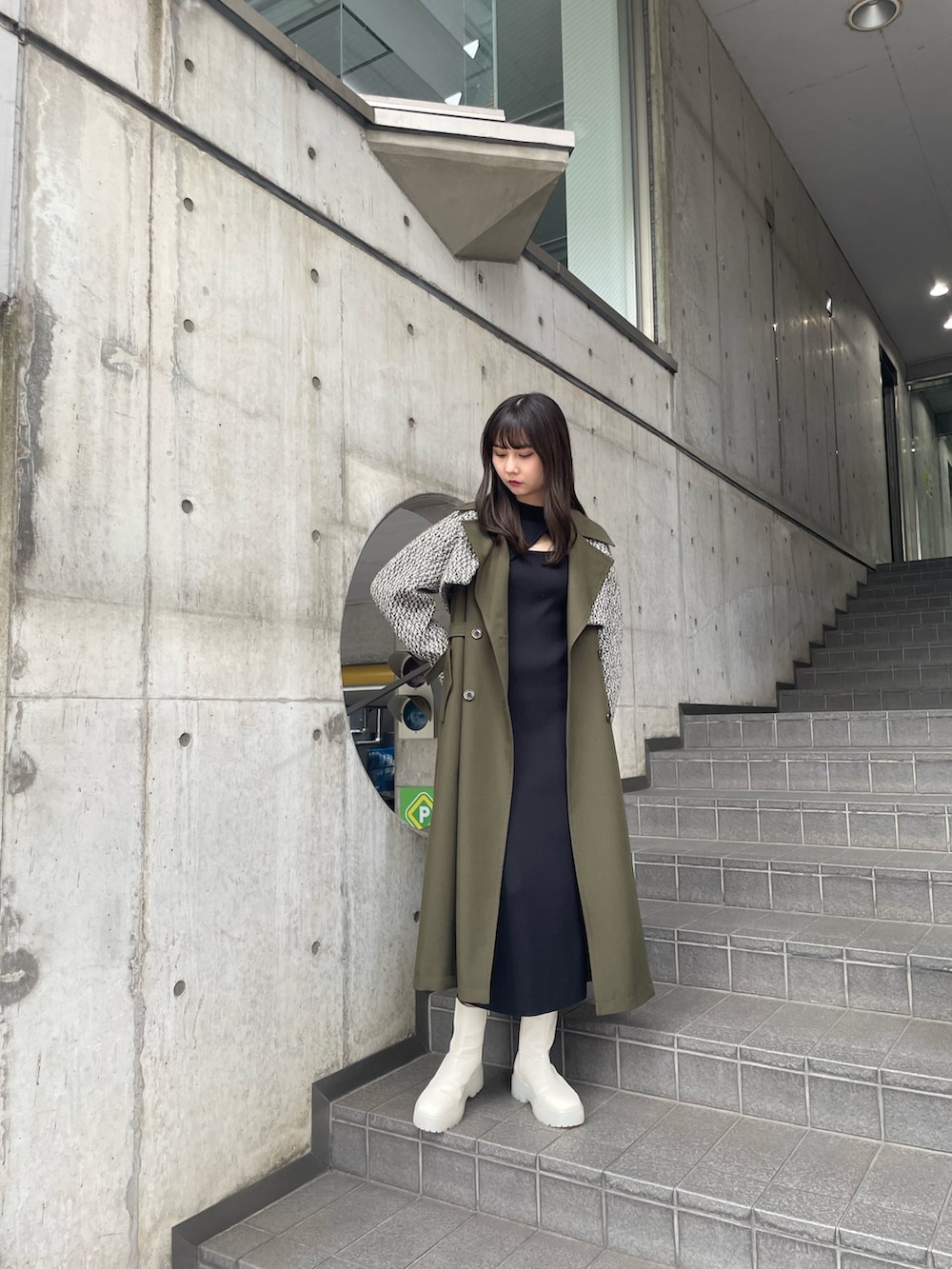 グリーン系のトレンチコートを着用したレディースの夏コーディネートの2枚目の写真