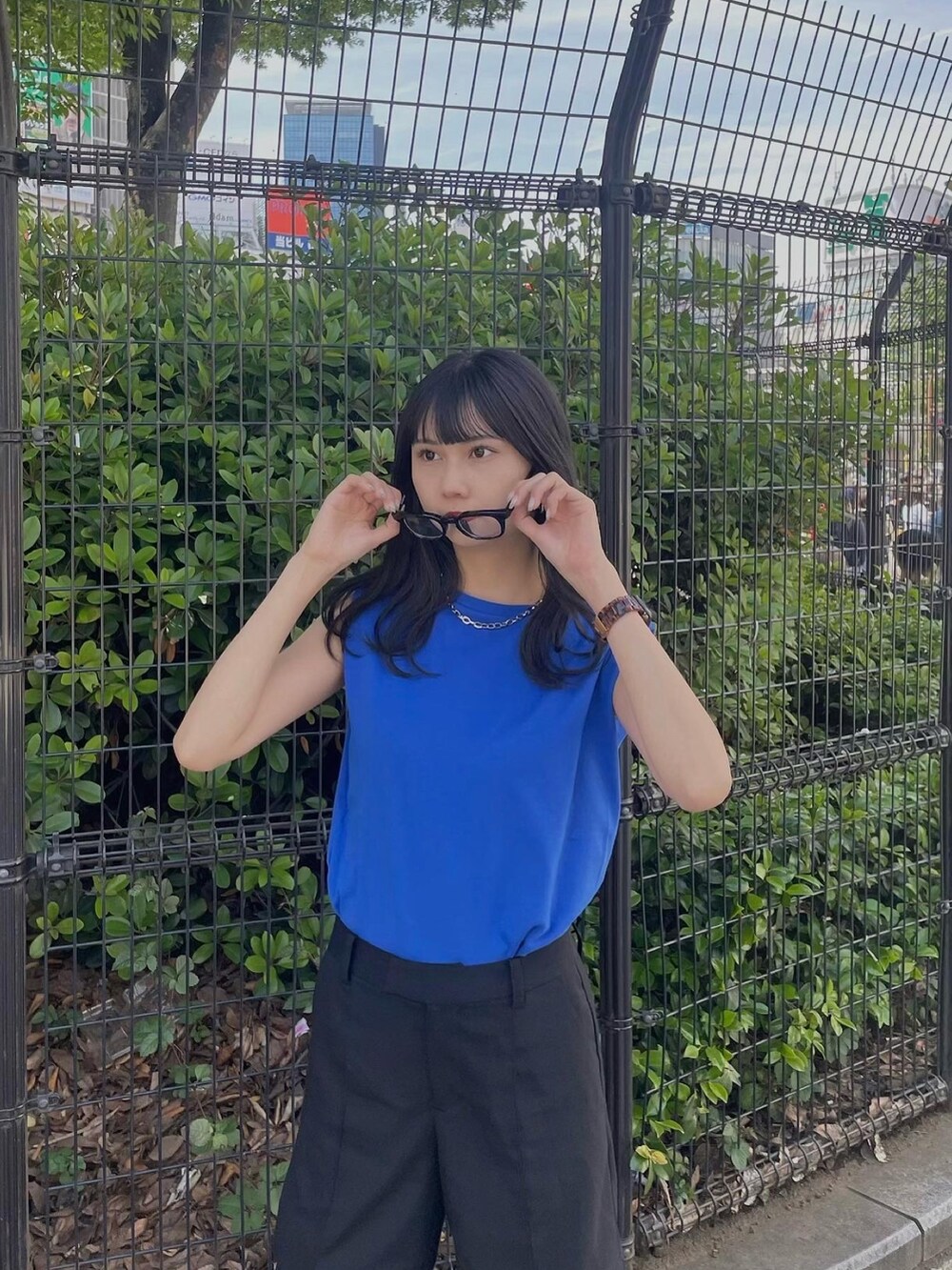 ブルー系のTシャツ/カットソー、ブラック系のスラックス、ブラック系のサンダルを着用したレディースの春コーディネートの4枚目の写真