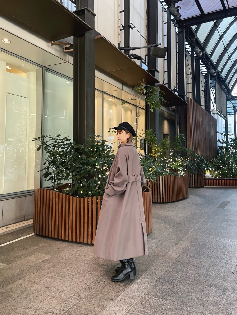 ブラウン系のステンカラーコートを着用したレディースの冬コーディネートの2枚目の写真