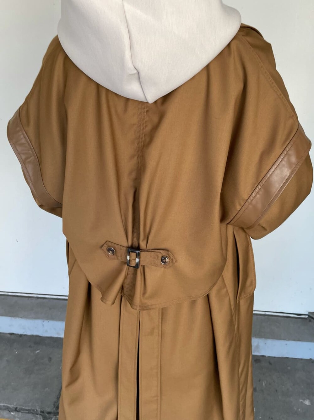 ブラウン系のトレンチコート、ブラック系のスラックス、ブラック系のブーツを着用したレディースの秋コーディネートの6枚目の写真