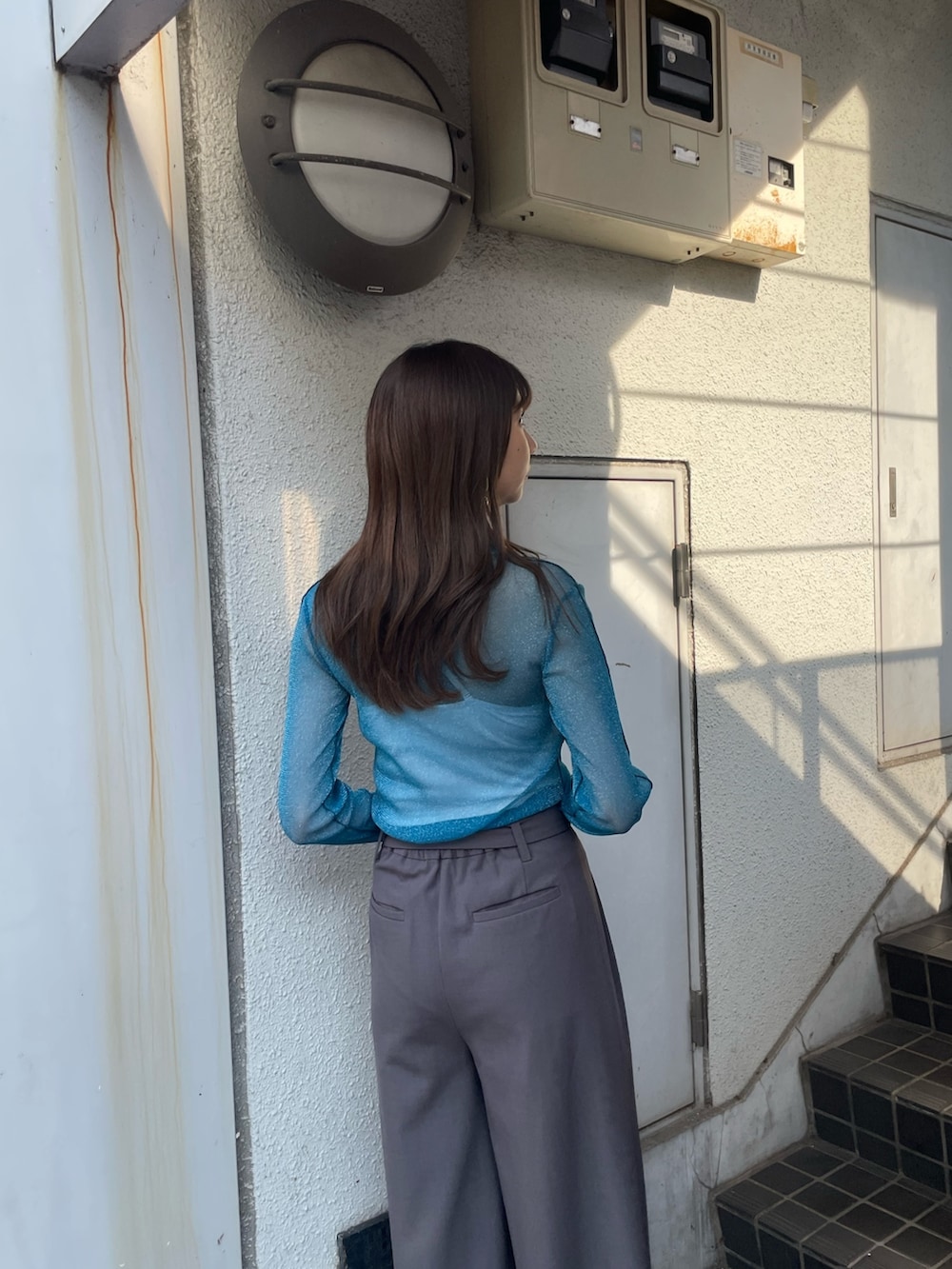 グレー系のスラックス、ブルー系のTシャツ/カットソー、ブラック系のブーツを着用したレディースの夏コーディネートの6枚目の写真