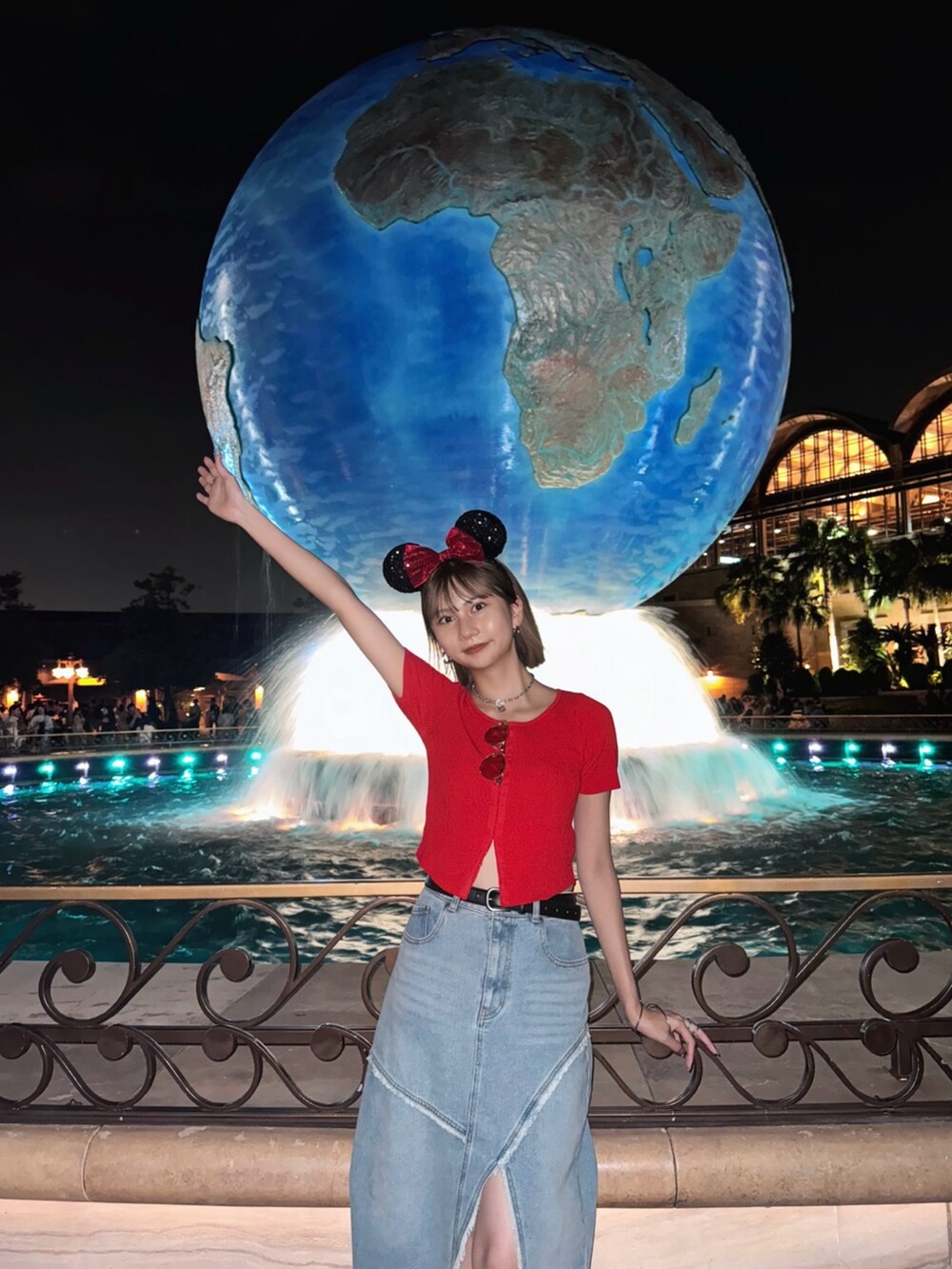 ブルー系のデニムスカート、レッド系のニット/セーター、シルバー系のパンプスを着用したレディースの夏コーディネートの4枚目の写真