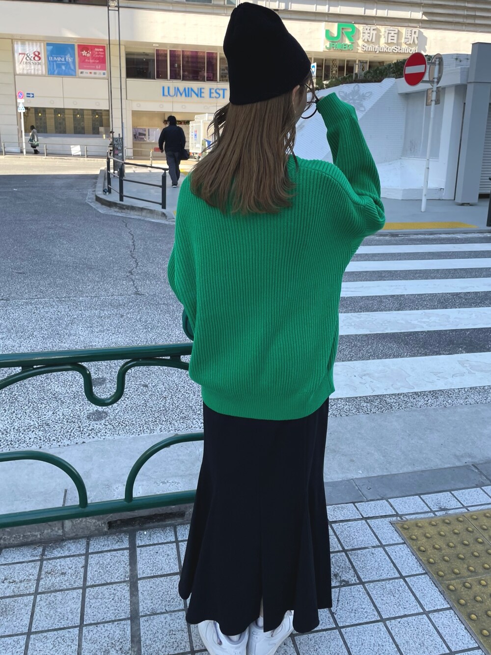 グリーン系のニット/セーター、グリーン系のハンドバッグ、ブラック系のスカートを着用したレディースの冬コーディネートの4枚目の写真